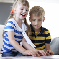 Two kids playing Yakety Pack cards at a table